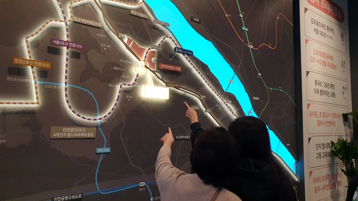 관람객들이 김포풍무 호반써밋 견본 주택 내 게시물을 살펴보고 있다.