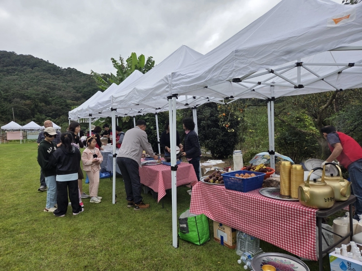 인곡마을 주민들이 직접 준비한 고구마와 따뜻한 차를 관객들에게 대접하고 있다.