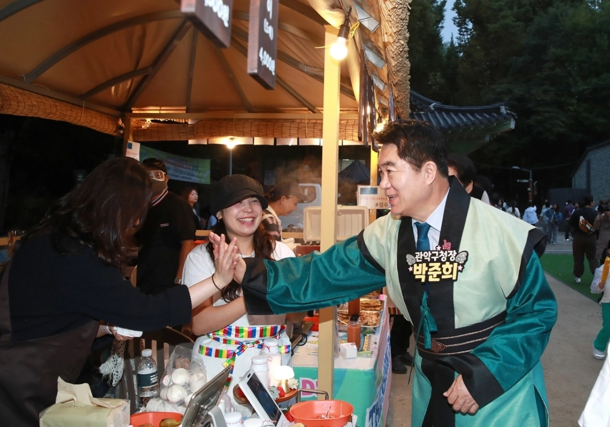 박준희(오른쪽) 서울 관악구청장이 ‘2025 관악강감찬축제’에서 ‘고려장터’ 부스를 운영 중인 상인들을 격려하고 있다. 관악구 제공