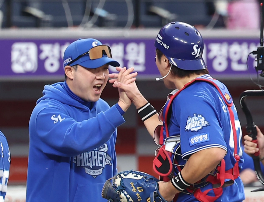 박진만 삼성 라이온즈 감독이 19일 대전 한화생명볼파크에서 열린 2025 플레이오프 2차전 한화 이글스와의 원정 경기에서 승리한 뒤 포수 강민호와 하이파이브하고 있다. 대전 뉴스1