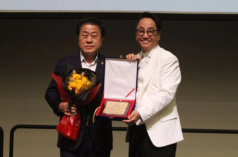 지난 19일 인천 송도컨벤시아 2층 프리미어 볼륨홀에서 열린 ‘제22회 국제바디아트콘테스트’에 참석한 김용호 의원(왼쪽)이 케이뷰티전문가연합회 황종열 회장으로부터 감사패를 받고 기념촬영을 하고 있다.