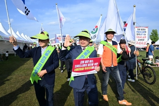 ‘구리가 서울되는 범시민추진위원회’ 가 지난해 5월 12일 구리한강시민공원에서 열린 2024구리유채꽃축제장에서 서울편입을 위한 범시민 서명운동을 전개하고 가두 행진을 하고 있다.[구리시 제공]