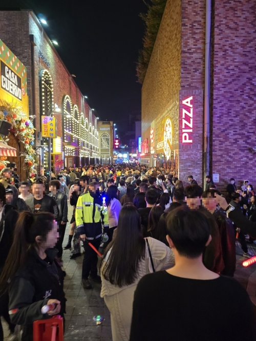 주말인 지난 25일 자정쯤 인파로 빼곡한 용산구 이태원 세계음식거리에서 한 경찰관이 통행을 관리하는 모습. 박효준 기자