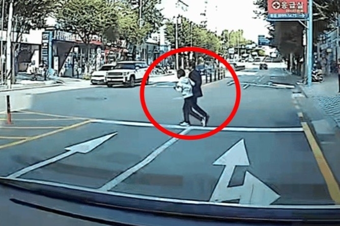 96억원 규모 다중 피해 사기 사건의 수배자 70대 남성(붉은 원)이 무단횡단을 하다 경찰에 붙잡혔다. 서울경찰청 기동순찰대 제공