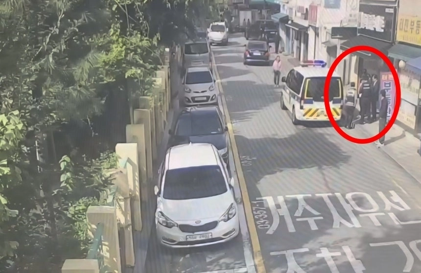 96억원 규모 다중 피해 사기 사건의 수배자 70대 남성이 무단횡단을 하다 경찰에 붙잡혔다. 경찰과 대치 중인 남성의 모습. 서울경찰청 기동순찰대 제공