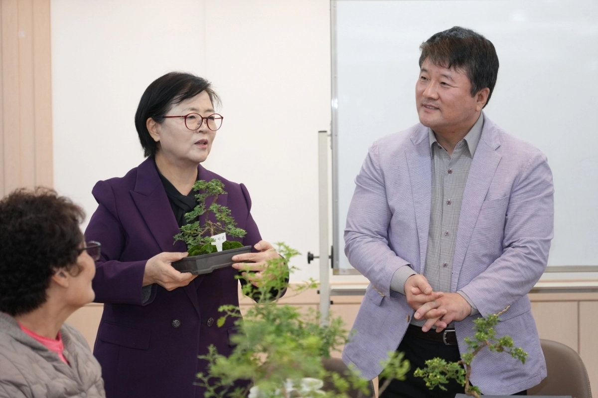 이순희(왼쪽) 서울 강북구청장이 화계중학교를 방문해 최중호 교장과 함께 평생학습 프로그램 ‘국화분재 수업’에 참여한 주민들과 대화를 나누고 있다. 강북구 제공