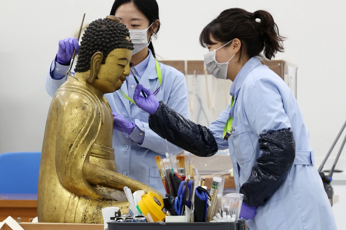 28일 서울 용산구 국립중앙박물관에서 ‘보존과학센터’ 개관식이 열린 가운데 보존과학센터 목재실 학예연구사들이 목재 불상 건식 세척 작업을 하고 있다. 뉴시스