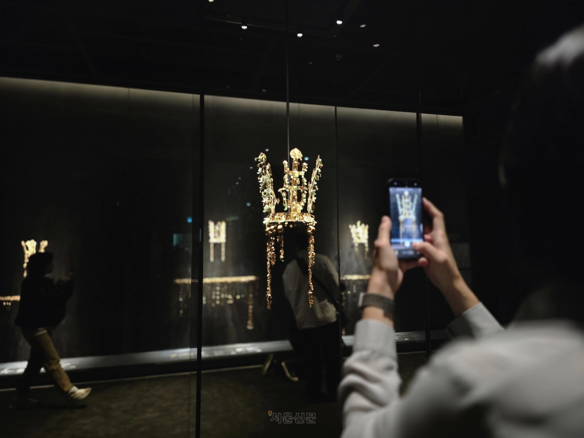 국립경주박물관이 2025 아시아태평양경제협력체(APEC) 정상회의를 기념해 특별전 ‘신라 금관, 권력과 위신’을 여는 가운데 27일 박물관 관계자가 국보인 황남대총 북분 금관을 휴대전화 카메라에 담고 있다. 서울신문DB