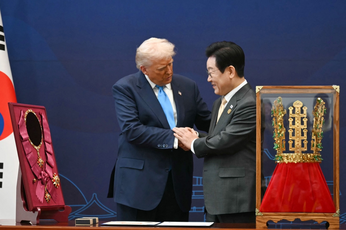 이재명 대통령이 29일 국립경주박물관에서 도널드 트럼프 미국 대통령에게 무궁화대훈장(왼쪽)을 수여한 뒤 악수하고 있다. 오른쪽은 역시 트럼프 대통령에게 선물한 천마총 금관 모형. 경주 아시아태평양경제협력체(APEC) 정상회의를 계기로 방한해 한미 정상회담을 진행한 트럼프 대통령은 30일 출국할 예정이다. 경주 AFP 연합뉴스