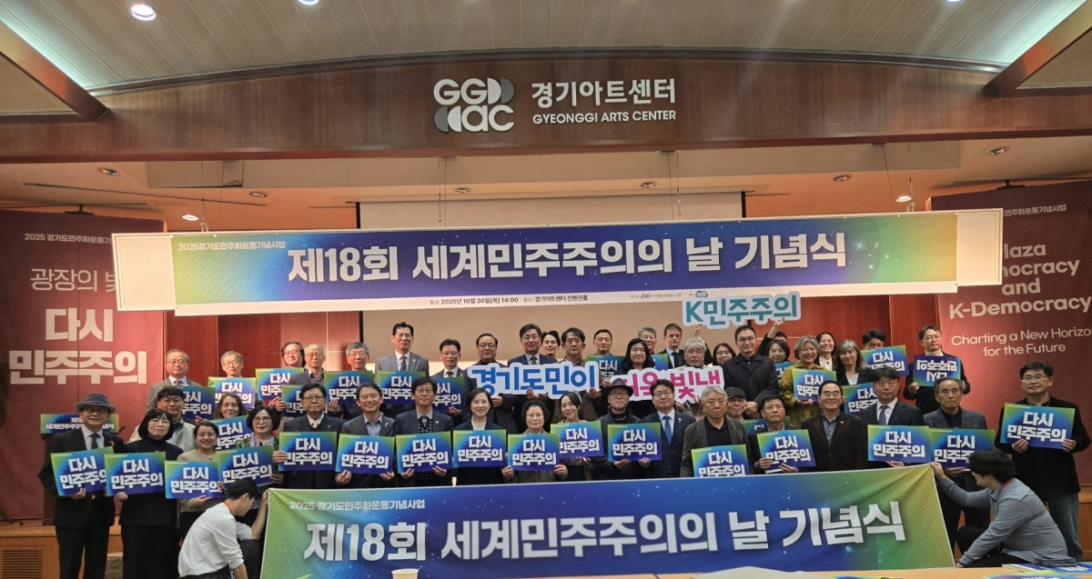 제18회 세계민주주의의 날 기념식이 10월 30일 경기아트센터 컨벤션홀에서 개최된 가운데, 참석자들이 ‘다시 민주주의’ 슬로건을 담은 피켓을 들고 기념촬영을 하고 있다.(사진=경기도의회)
