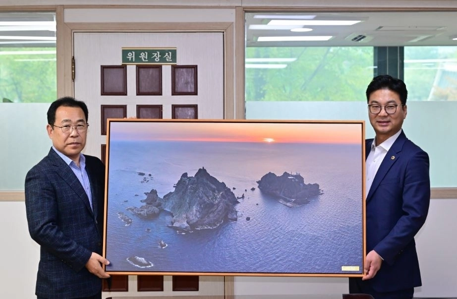 정책간담회 종료 후 울릉군의회 의장이 장태용 위원장에게 대형 독도 사진 액자를 증정하고 있다.