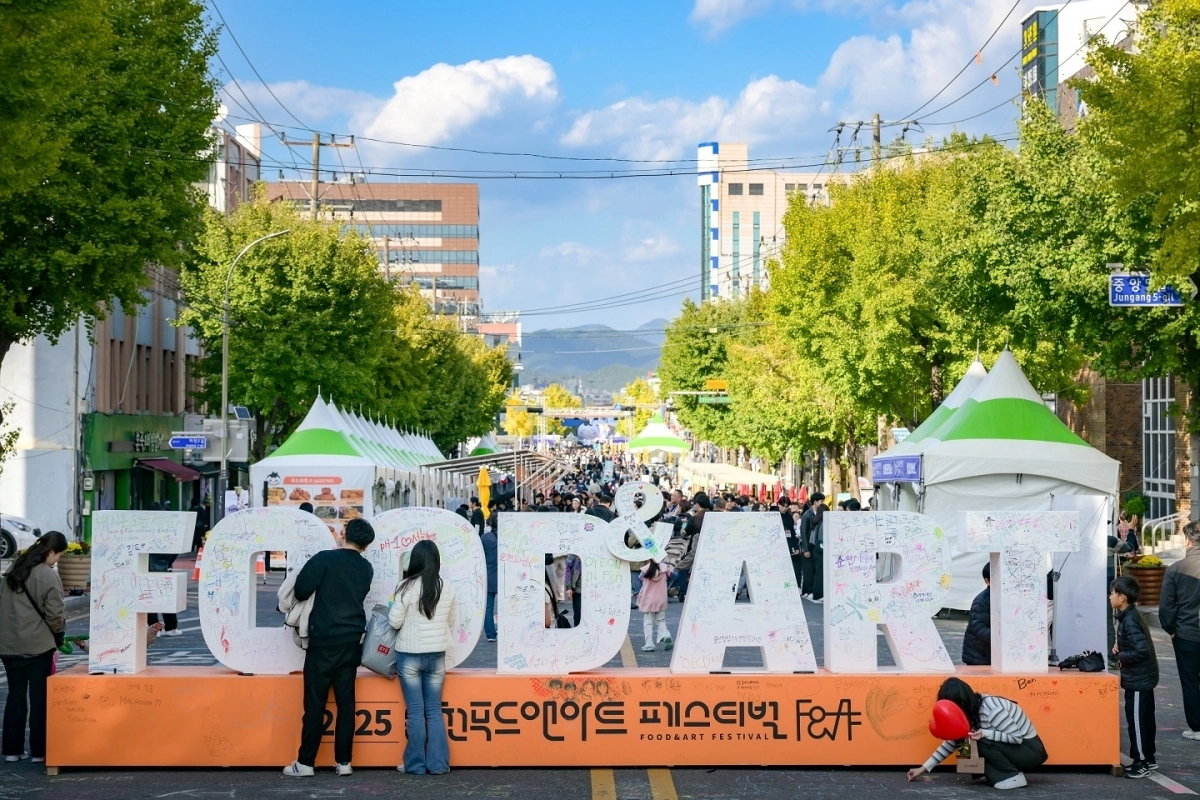 푸드앤아트페스티벌 레터링 조형물에 관람객들이 방문 후기를 적고 있다.