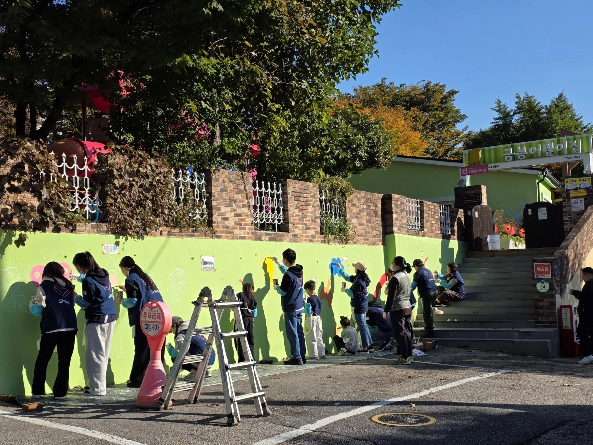 지난 1일 성동구와 SM엔터테인먼트 관계자들이 함께 구립금봉어린이집 노후 시설에 벽화를 조성 중인 모습. 성동구 제공