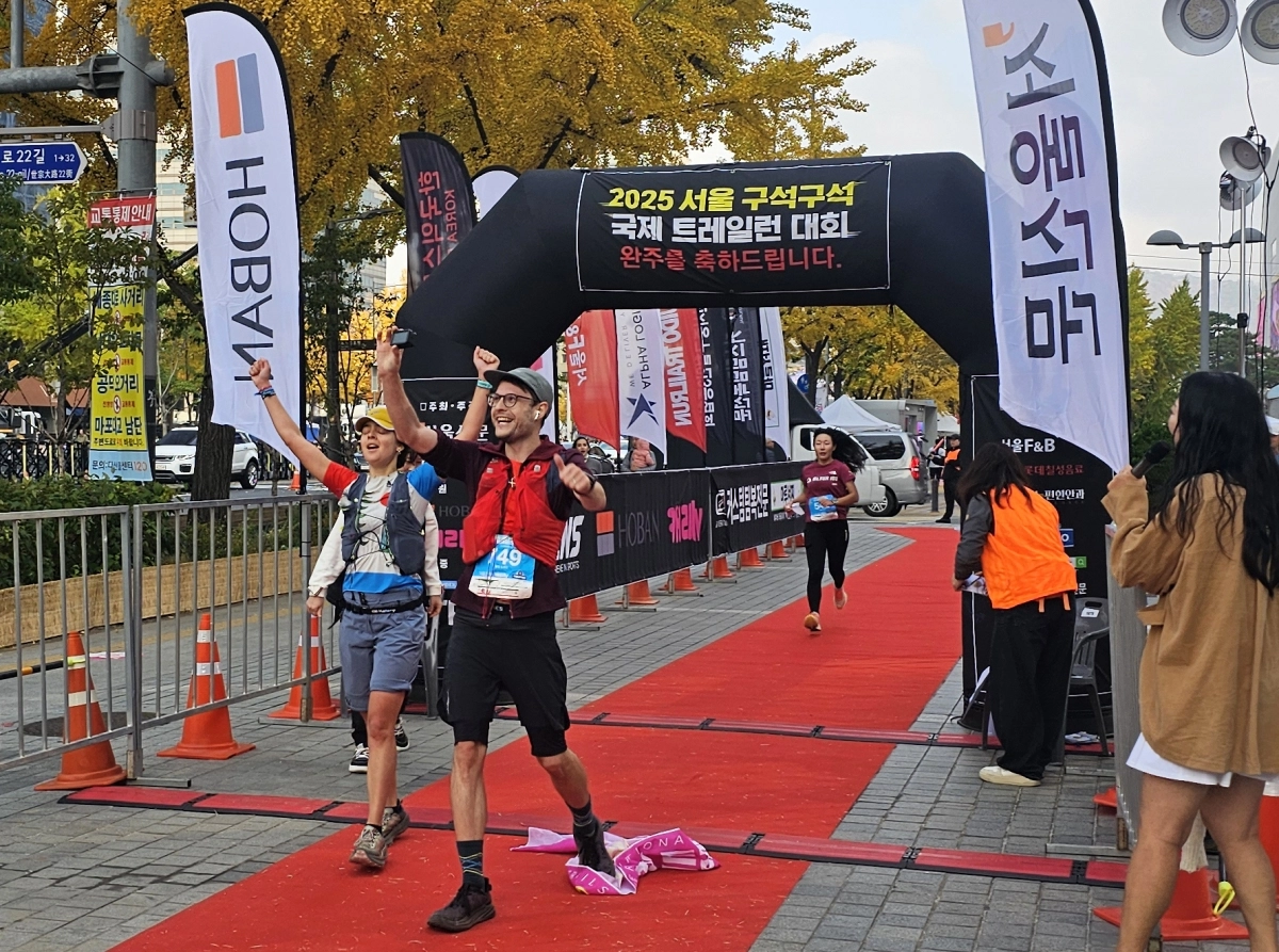 9일 ‘2025 서울 구석구석 국제 트레일런 대회’에서 참가자들이 서울 중구 세종대로 서울신문사 앞 서울마당에 설치된 결승선을 통과하고 있다.  이탈리아에서 온 참가자 엘리사(왼쪽)가 1시간 39분의 기록으로  12㎞ 여자 부문에서 우승을 차지했다.