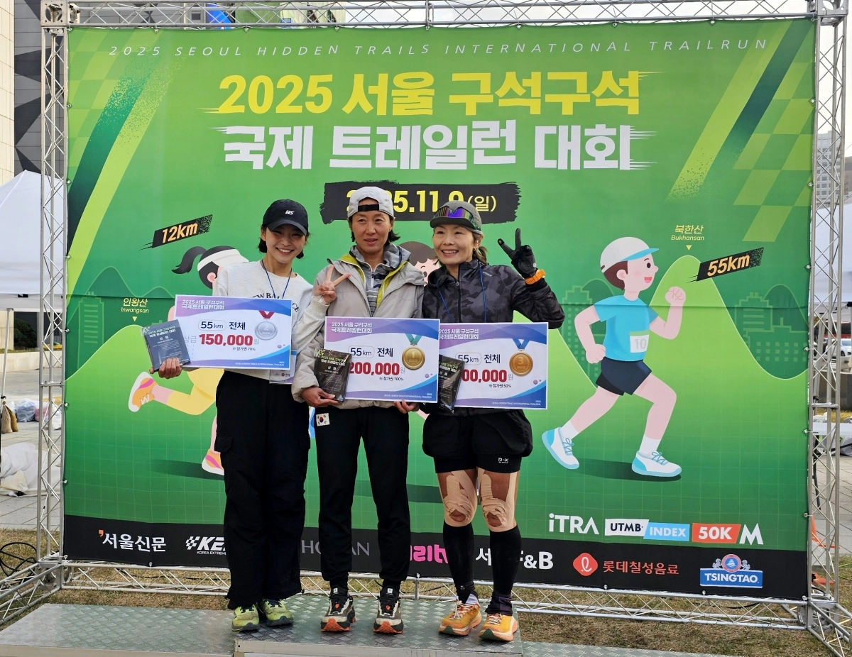 ‘2025 서울 구석구석 국제 트레일런 대회’ 55㎞ 여자 부문에서 입상한 선수들이 상패를 들고 기념 촬영을 하고 있다.  가운데가  8시간 45분의 기록으로 우승을 차지한  황지호씨.