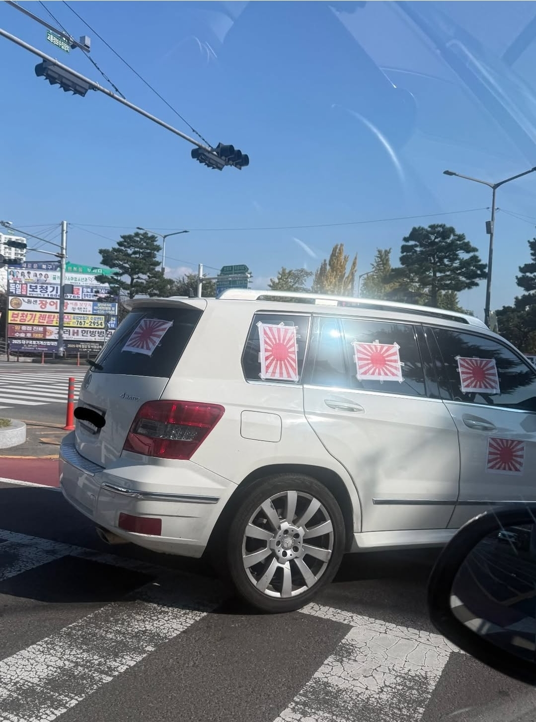 흰색 벤츠 SUV 차량 오른쪽 옆면과 뒷면 창문과 차체에 욱일기 여러 장이 붙어 있다. 인스타그램 보배드림 계정