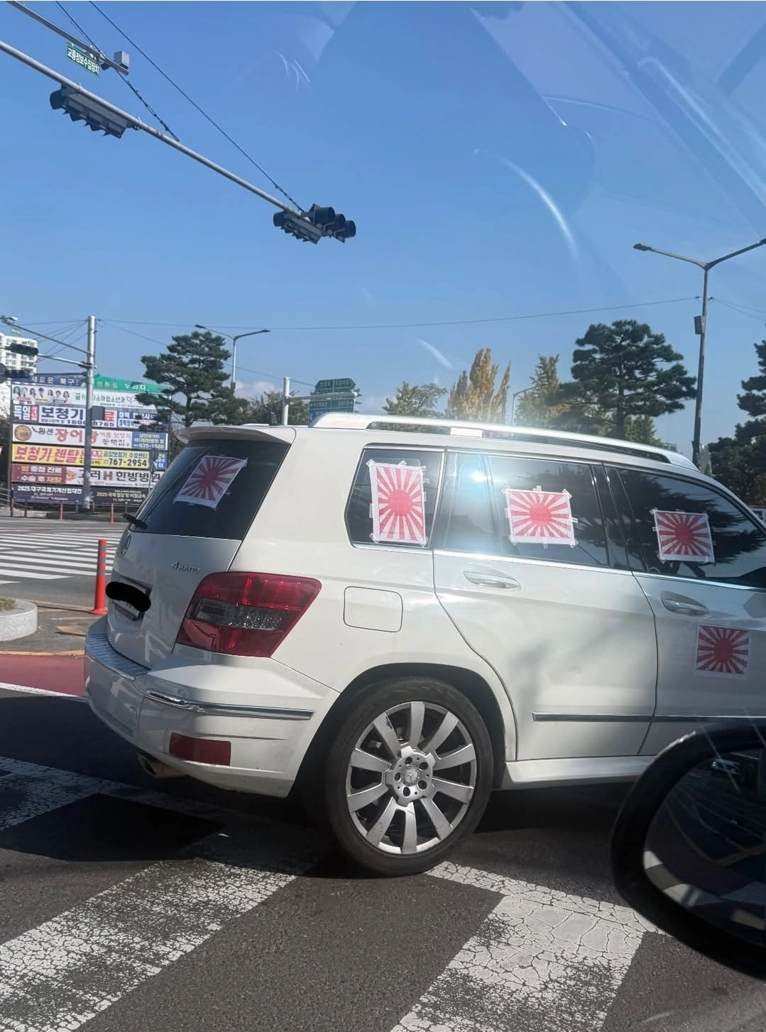 흰색 벤츠 SUV 차량 오른쪽 옆면과 뒷면 창문과 차체에 욱일기 여러 장이 붙어 있다. 인스타그램 보배드림 계정