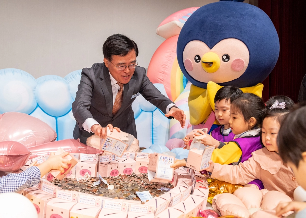 진교훈 서울 강서구청장이 지난 3월 열린 ‘사랑의 저금통 마음모으기’ 전달식에서 아이들과 함께 동전을 모으고 있다. 강서구 제공
