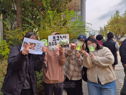 13일 오전 서울 영등포구 여의도여고 앞에서 만난 이소연(27)씨(오른쪽에서 첫 번째)는 아이돌 그룹 응원봉을 들고 “이번에 시험을 보는 언니가 원하는 학과에 찰떡같이 붙었으면 좋겠다”고 말했다. 송현주 기자