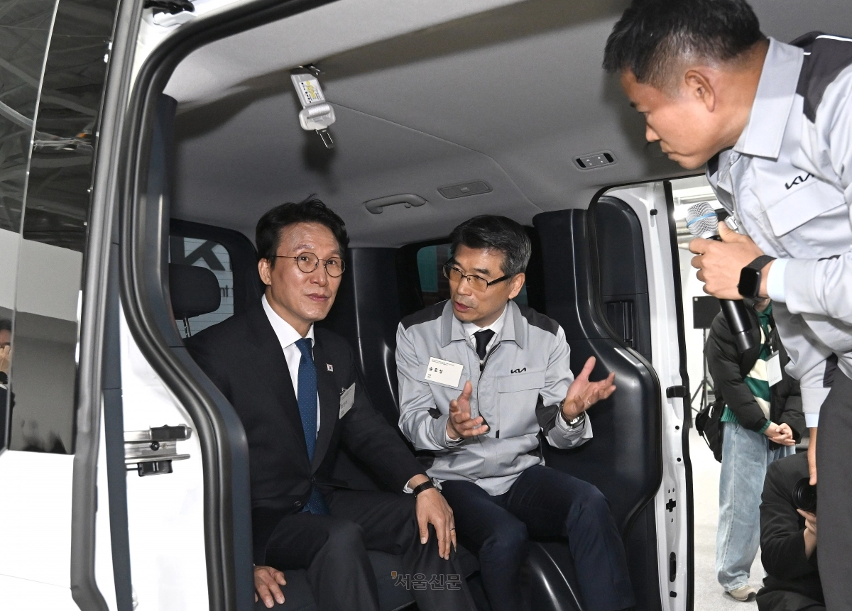 김민석(왼쪽) 국무총리가 14일 경기 화성시 우정읍 기아오토랜드 화성에서 열린 기아 화성 EVO 플랜트 East 준공·West 기공 기념행사에서 송호성 기아 사장의 설명을 듣고 있다. 2025.11.14 현대차·기아 제공