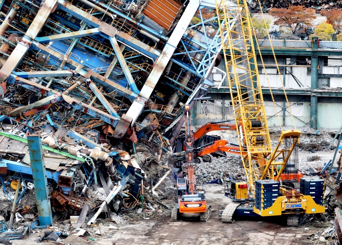 지난 12일 오후 울산화력발전소 보일러타워(5호기)에서 추가 붕괴를 막기 위해 크레인으로 상부 구조물을 고정한 뒤 중장비가 진입로를 확보하고 있다. 2025.11.16. 연합뉴스