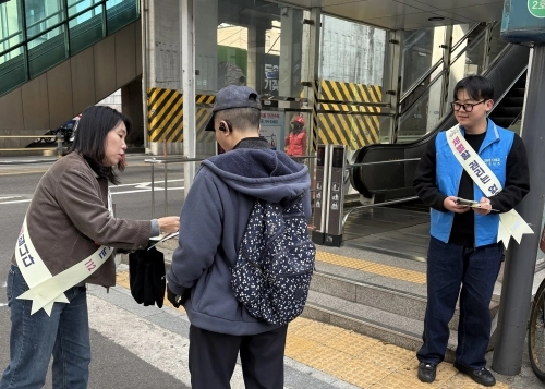 서울 광진구 관계자가 아동학대 예방의 날을 맞이해 지난 11일 구의역 일대에서 시민들에게 아동학대 예방 중요성을 알리고 있다.   광진구 제공