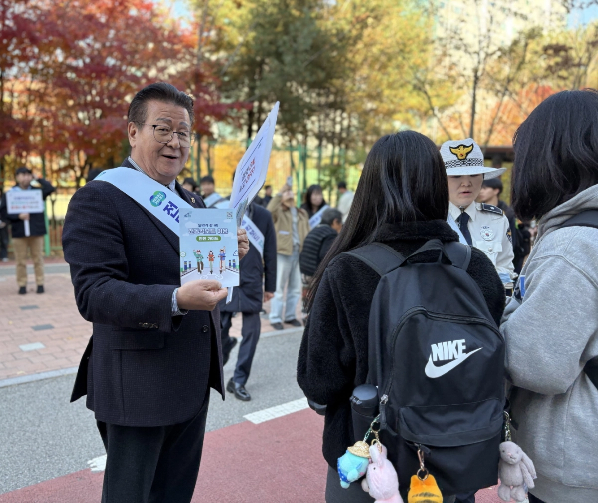 안명규 의원이 파주 금릉역 인근에서 학생들에게 개인형 이동장치(PM) 안전수칙을 직접 안내하며 안전문화 정착을 위한 캠페인에 참여하고 있다(사진=경기도의회)