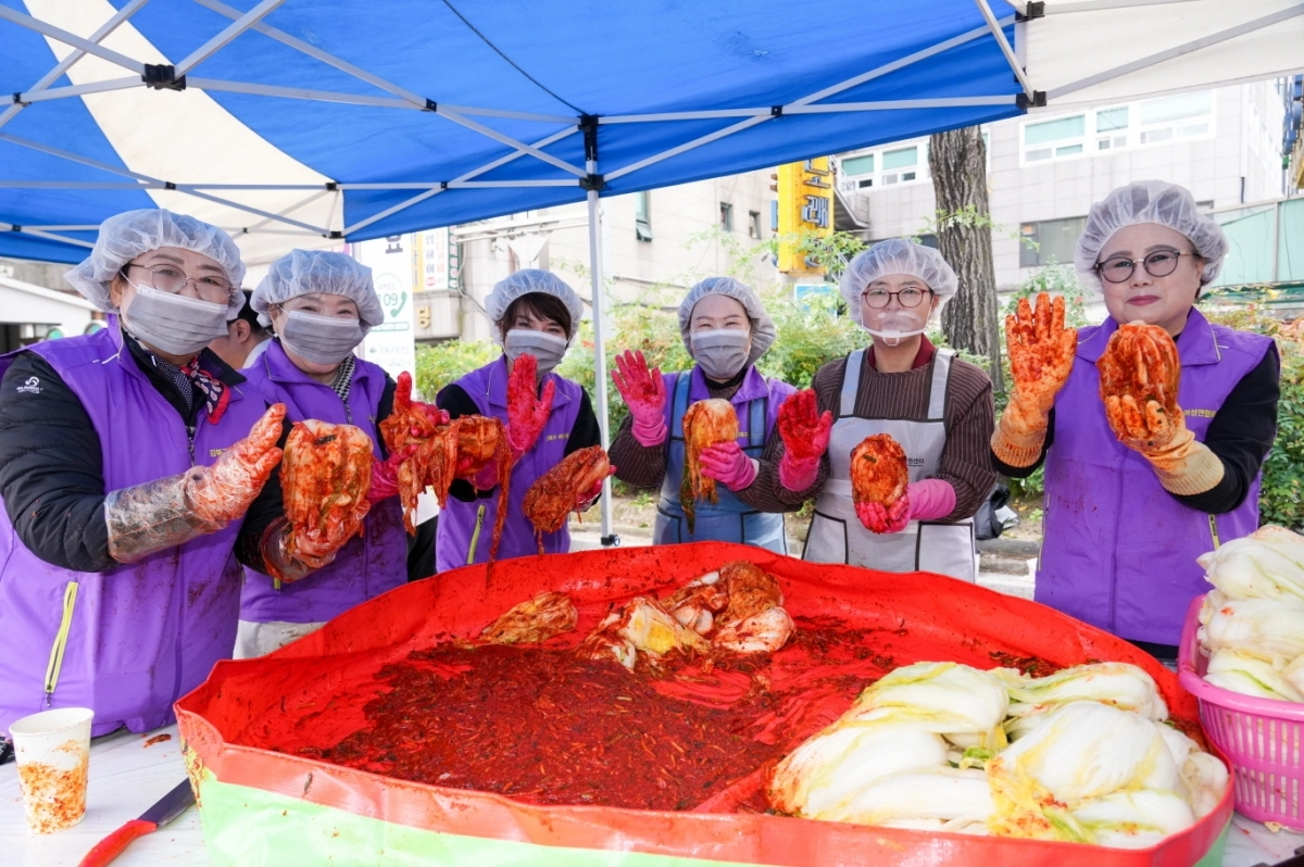 이순희(오른쪽 두 번째) 서울 강북구청장이 지난 13일 구청 광장에서 열린 ‘다문화가정 김장 나눔’행사에서 주민들과 직접 담근 김치를 들고 기념사진을 찍고 있다. 강북구 제공
