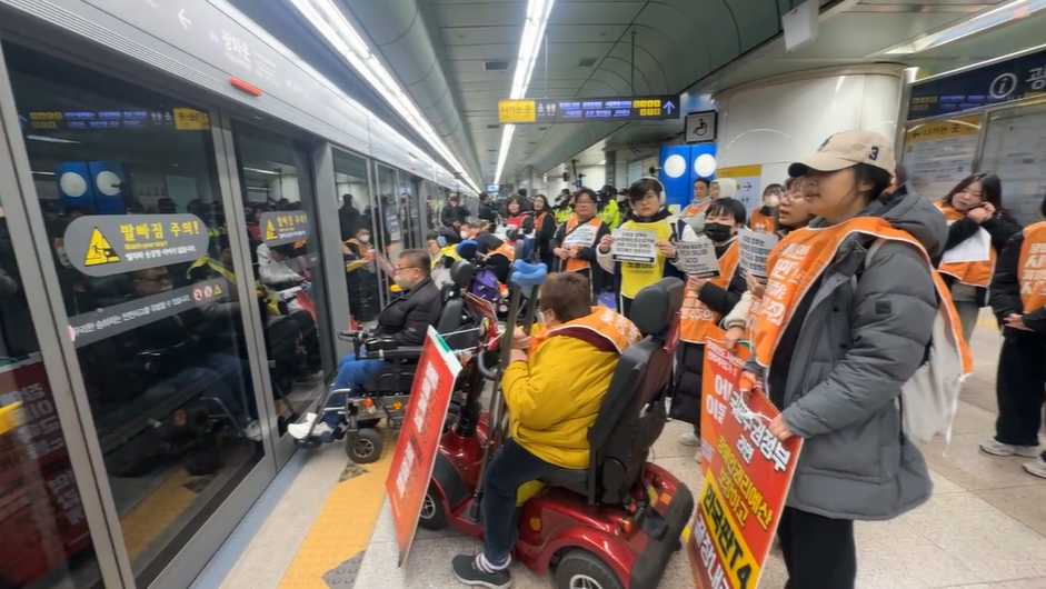 전국장애인차별철폐연대(전장연) 활동가들이 18일 오전 서울지하철 5호선 광화문역에서 ‘출근길 지하철 탑니다’ 시위를 벌이고 있다. 전장연 공식 페이스북 캡처