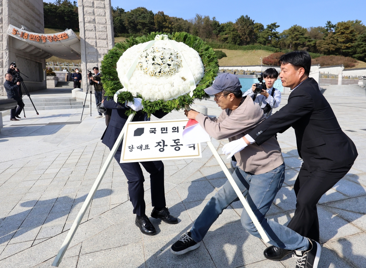지난 6일 오후 광주 북구 국립5·18민주묘지에서 국민의힘 장동혁 대표의 참배 화환을 시민단체 관계자가 이동시키고 있다. 2025.11.6. 연합뉴스