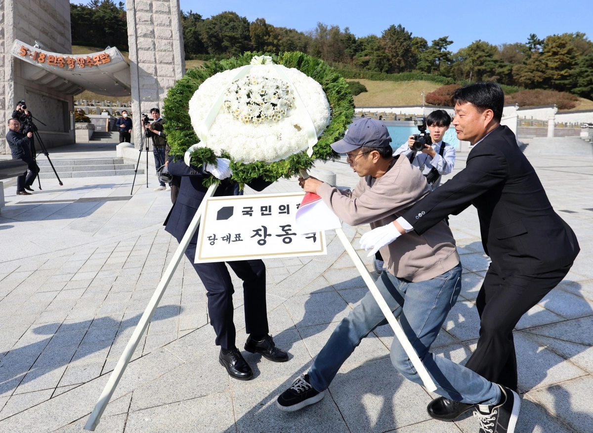 지난 6일 오후 광주 북구 국립5·18민주묘지에서 국민의힘 장동혁 대표의 참배 화환을 시민단체 관계자가 이동시키고 있다. 2025.11.6. 연합뉴스
