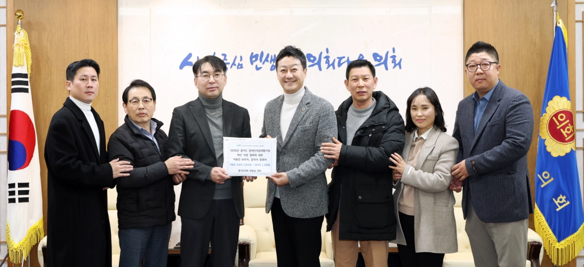 김진경 의장이 경기도장애인직업재활시설협회 임효순 회장으로부터 ‘경기도장애인직업재활시설 이용인 보호자 및 종사자 동의서’를 전달받고 관계자들과 기념촬영을 하고 있다.(사진=경기도의회)