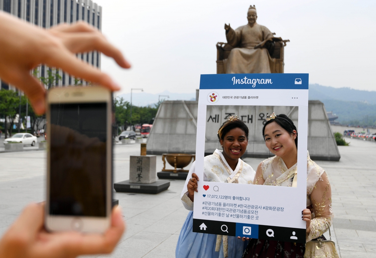 서울 광화문 세종대왕상 앞에서 기념 사진을 찍는 관광객들. 서울신문 포토라이브러리.