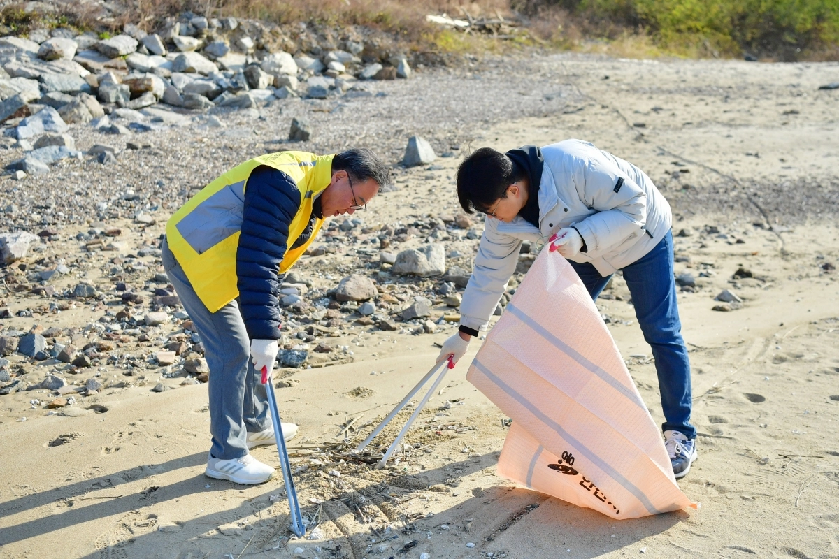 경기신용보증재단 시석중 이사장(왼쪽)이 19일 안산  대부도 방어머리 해수욕장 일대에서 임직원들과 함께 ‘경기바다 함께해(海)’ 해양 정화 활동을 했다. (경기신보 제공)