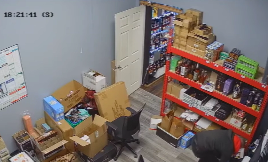 빨간색 후드티를 입은 한 남성이 주류 판매점 뒤편에 있는 사무실 내부를 뒤지고 있다. 유튜브 채널 ‘KPTV 폭스12’ 캡처