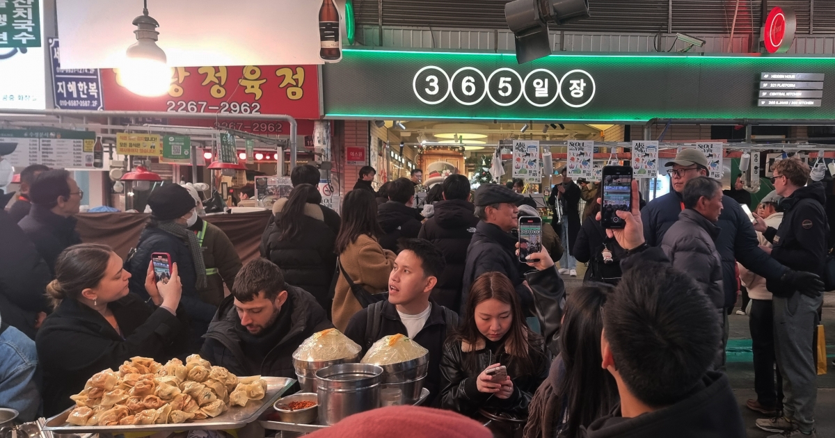 18일 서울 광장시장에서 열린 ‘2025 서울바이브’ 행사에서 클래식 연주자들이 공연을 시작하자 칼국수를 먹고 있던 외국인 관광객들이 휴대폰을 꺼내 촬영을 하고 있다.