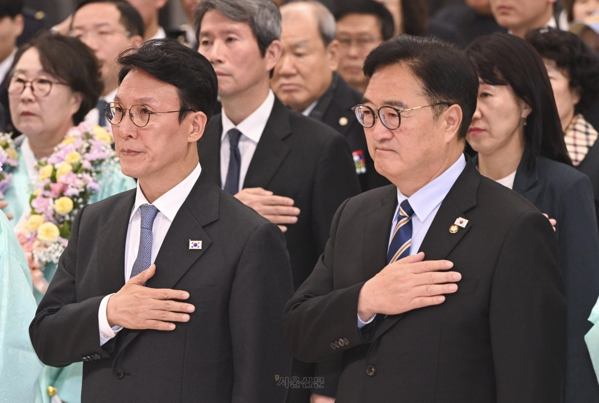 김민석(왼쪽) 국무총리와 우원식 국회의장이 23일 서울 강서구 김포국제공항 국제선 입국장에서 열린 ‘대한민국임시정부 요인 환국 재현’ 행사에서 국기에 대한 경례를 하고 있다. 2025.11.23 이지훈 기자