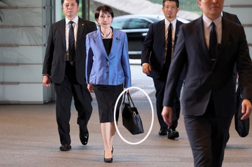 다카이치 사나에 일본 총리가 지난 21일 도쿄 총리 관저로 들어가고 있다. 다카이치 총리 내각은 지난 21~23일 요미우리신문 설문조사에서 72%의 높은 지지율을 얻었으며, 덩달아 그가 들고 다니는 검은 가방 ‘사나에 토트백’도 품절 현상을 빚었다. 도쿄 로이터 연합뉴스
