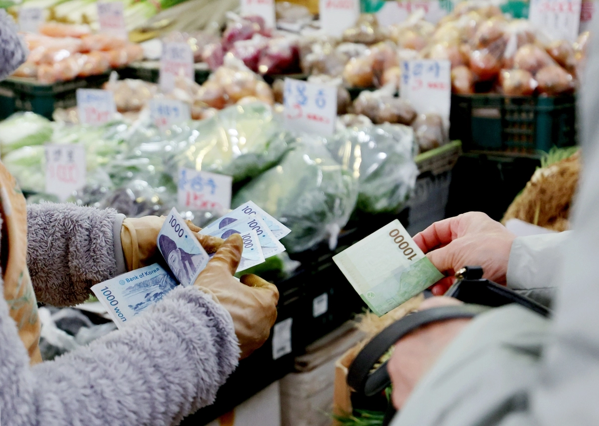 25일 서울 시내 전통시장에서 한 시민이 채소를 구매하기 위해 지폐를 들고 있다. 이날 한국은행에 따르면 11월 소비자심리지수(CCSI)는 112.4로, 2017년 11월(113.9) 이후 가장 높은 수치를 기록했다. 뉴시스