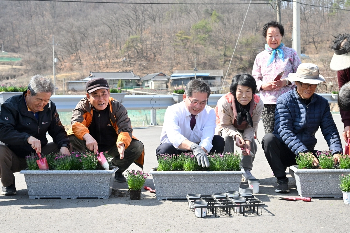군위읍 금구2리 주민들이 군위형 마을만들기 사업의 하나로 마을 입구에 꽃 화분을 설치하고 있다. 군위군 제공