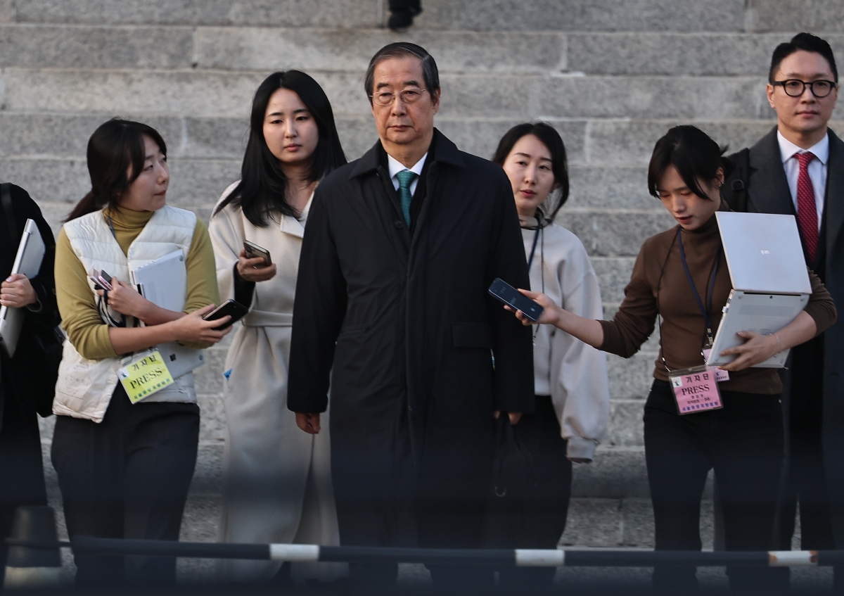 내란 우두머리 방조 등 혐의로 재판에 넘겨진 한덕수(가운데) 전 국무총리가 26일 서울 서초구 서울중앙지법에서 열린 1심 결심 공판을 마치고 법원을 나서고 있다. 내란 특검은 이날 한 전 총리에게 징역 15년을 선고해 달라고 요청했다. 연합뉴스