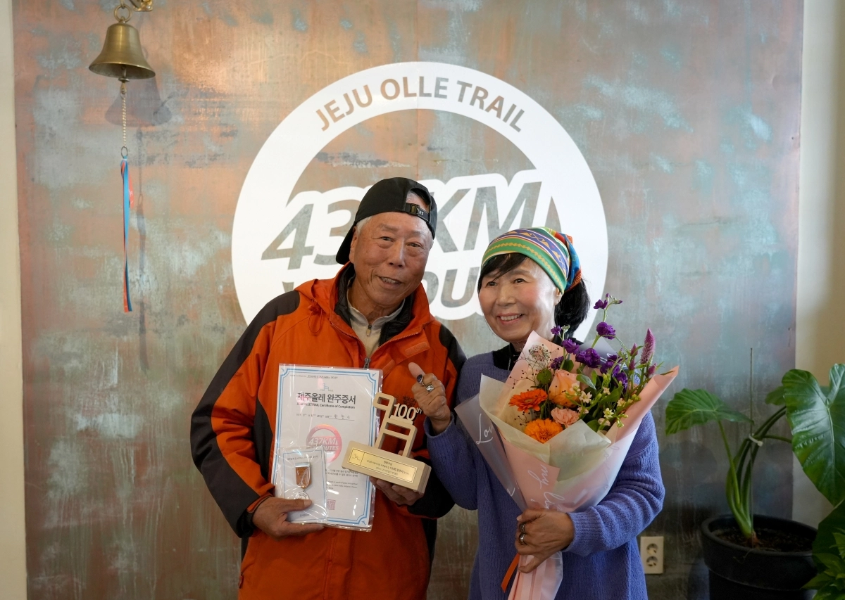 만 80세 한창수씨가 제주올레길을 사상 첫 100회 완주하는 대기록을 작성한 뒤 서명숙 사단법인 제주올레 이사장과 기념촬영을 하고 있다. 제주올레 제공