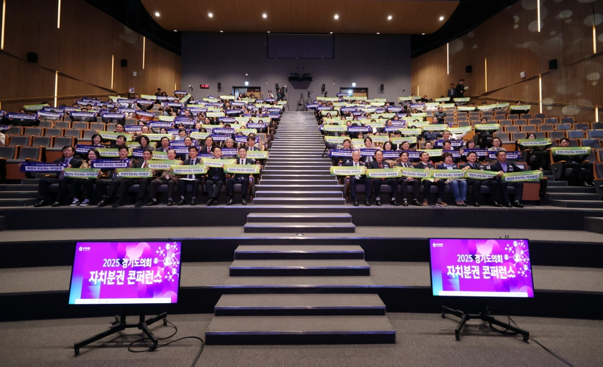 ‘2025 경기도의회 자치분권 콘퍼런스’에 참석한 참가자들이 자치분권 실현을 염원하는 문구가 적힌 손피켓을 들고 기념촬영을 하고 있다.(사진=경기도의회)