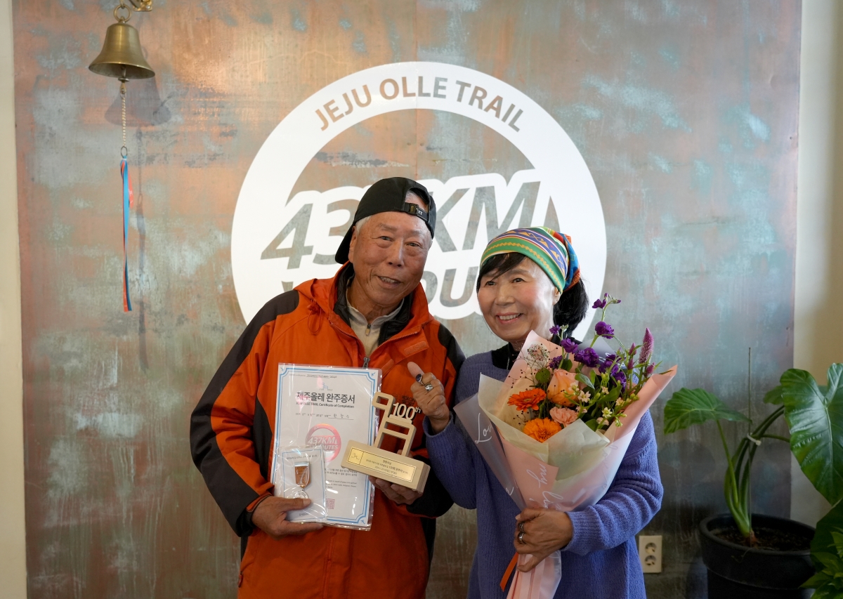 한창수(왼쪽)씨가 제주올레길 사상 첫 100회 완주 대기록을 작성한 뒤 서명숙 사단법인 제주올레 이사장과 기념촬영을 하고 있다. 제주올레 제공