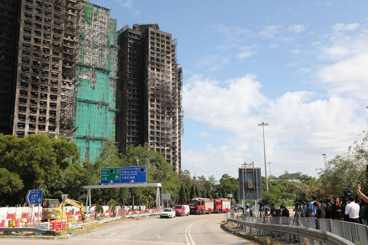 29일(현지시간) 대형 화재가 발생한 홍콩 북부 타이포 아파트 단지 ‘웡 푹 코트’ 앞에서 취재진과 주민들이 참사 현장을 바라보고 있다. 2025.11.29 연합뉴스