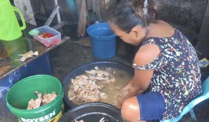 필리핀 여성이 버려진 고기를 대야에 담아 씻고 있다. 이후 음식 찌꺼기는 판매상들에게 팔린다. 더우인