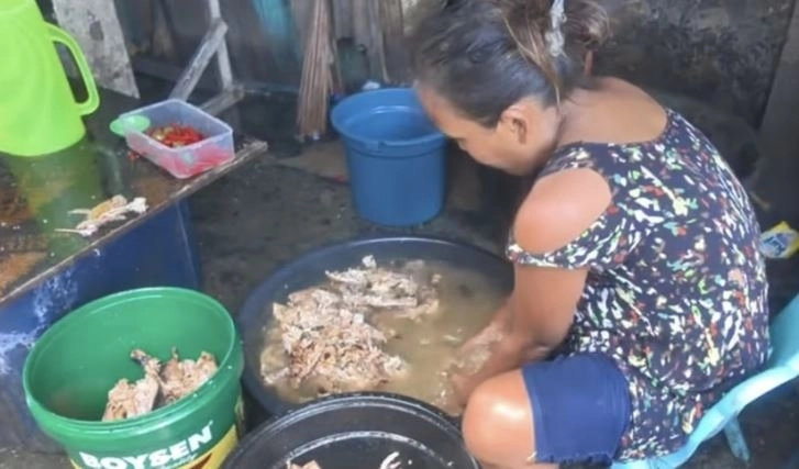 필리핀 여성이 버려진 고기를 대야에 담아 씻고 있다. 이후 음식 찌꺼기는 판매상들에게 팔린다. 더우인