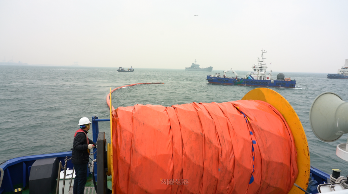 해양환경공단 방제선이 대규모 유류 확산에 따른 해상오염을 막기 위해 오일펜스를 설치하고 있다.