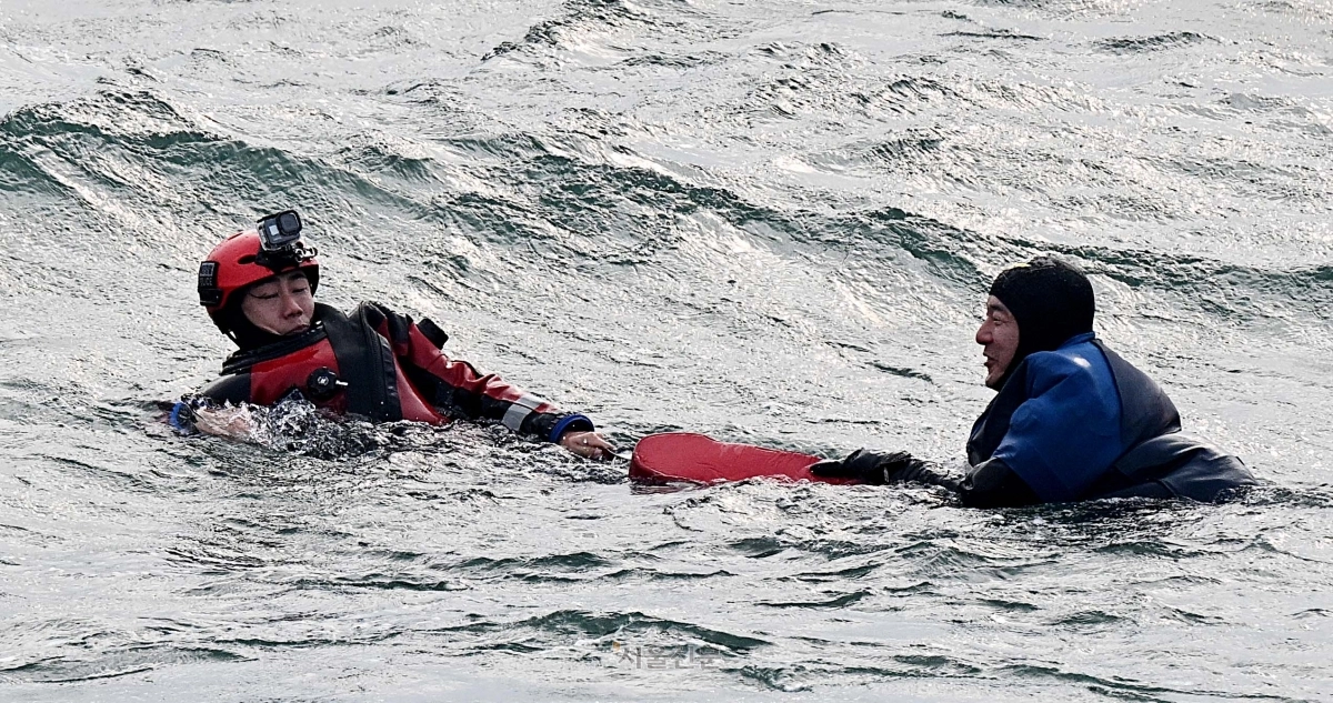 인천해경 대원이 부표를 이용해 표류자를 구조하고 있다.