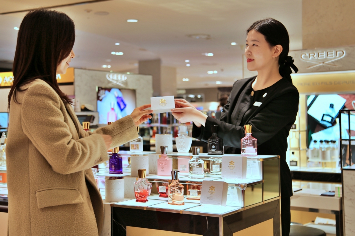 광주신세계 본관 2층 ‘크리드’ 매장에서 직원이 고객에게 샘플을 건네고 있다. 광주신세계 제공.